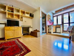 un ampio soggiorno con pavimenti in legno e TV di Monolocale accogliente a Bardonecchia