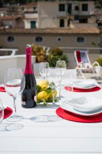 een tafel met wijnglazen en een fles wijn bij Rooftop 19_Amalfi Luxury Suite in Amalfi