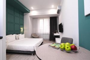 葉瑞文的住宿－Sweet Home Apart-Hotel，酒店客房,配有一张床和一张桌子,还有一碗水果