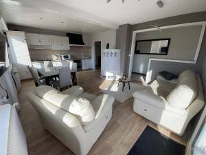 sala de estar con 2 sofás blancos y cocina en Domaine Rosfelder - locations de gîte et cabane insolite en Gertwiller