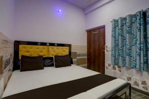 um quarto com uma cama grande num quarto em OYO Mansi Hotel em Alīgarh