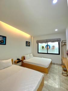 a bedroom with two beds and a window at HANID Hotel in Tuy Hoa