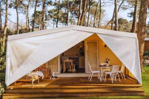 una tenda su una terrazza con tavolo e sedie. di Camping Village Le Calanchiole a Capoliveri