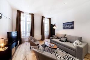 uma sala de estar com um sofá e uma televisão em Pure happiness -AC and balneotherapy AIL em Lyon