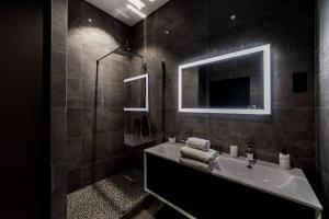 a bathroom with a sink and a mirror at Pur bonheur Hôtel de ville - clim et balnéo AIL in Lyon