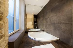 uma casa de banho com 2 lavatórios e uma banheira em Pure happiness -AC and balneotherapy AIL em Lyon