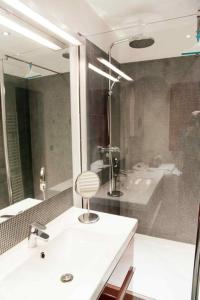 a bathroom with a sink and a tub and a mirror at Saint-Paul Vieux Lyon - parking included in Lyon