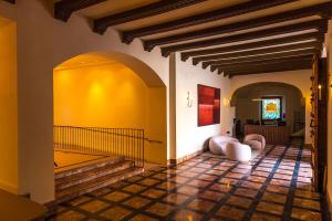 sala de estar con escaleras y pared amarilla en Palacio Valderrabanos, en Ávila