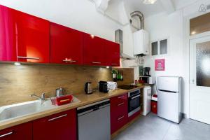 een keuken met rode kasten en een witte koelkast bij Perfect to visit Lyon with family or friends AIL in Lyon