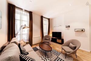 a living room with a couch and two chairs and a television at 70m2 of pure happiness in the centre - Rhône in Lyon