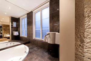 a bathroom with a tub and a large window at 70m2 of pure happiness in the centre - Rhône in Lyon