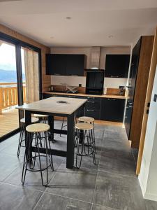 a kitchen with a table and stools in a room at Appartement bas de chalet in Font-Romeu-Odeillo-Via