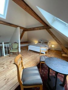 a attic room with a bed and a table and chairs at Refugium Maikammer im "Haus Lotter" in Maikammer