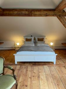 a bedroom with a white bed and two chairs at Refugium Maikammer im "Haus Lotter" in Maikammer