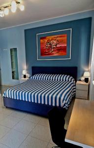 a bedroom with a bed with a blue wall at Scilla Guest House in Scilla