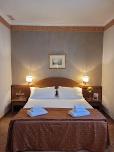 a bedroom with a large bed with two towels on it at Hotel Squarciarelli in Grottaferrata