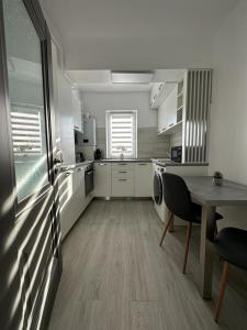 a large white kitchen with a table and chairs at Cozy Holidays in Center of Suceava Esplanada in Suceava