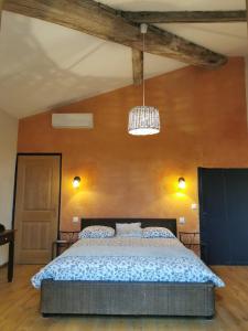 1 dormitorio con 1 cama y pared de madera en Le Mas Neuf des Greses, en Canaules-et-Argentières