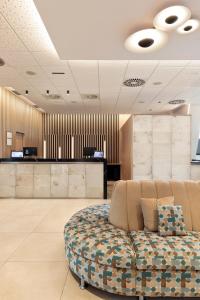 a lobby with a couch in the middle of a room at Hotel Best 4 Barcelona in Barcelona