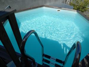 una piscina con una silla en el agua en Bungalow des papayes, en Saint-Louis