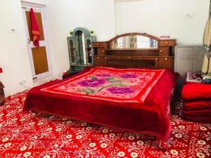 um quarto com uma cama grande e um cobertor vermelho em Habib Guest House (Gulmarg) em Gulmarg