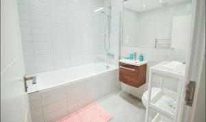 a bathroom with a tub and a toilet and a sink at Splendid Euston flat in London