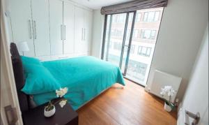 a bedroom with a blue bed and a large window at Splendid Euston flat in London