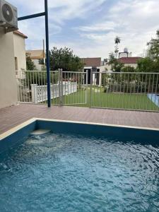 a pool of blue water in front of a fence at استراحه دانه بالمدينه المنوره in Al ‘Uqūl