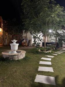 a stone path in a yard with a white fountain at استراحه دانه بالمدينه المنوره in Al ‘Uqūl