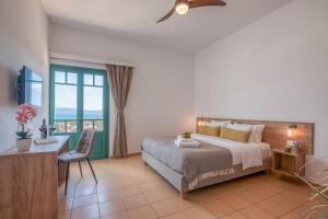 Schlafzimmer mit einem Bett, einem Schreibtisch und einem Fenster in der Unterkunft Kaliviani Traditional Hotel in Kissamos