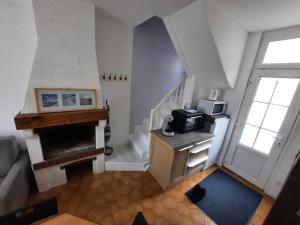 a living room with a staircase and a microwave at Maison Les Cordiers in Le Tréport