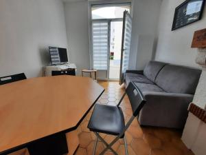 a living room with a table and a couch at Maison Les Cordiers in Le Tréport