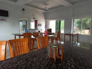 a dining room with wooden tables and chairs at Sea Wave Beach Resort in Tajpur