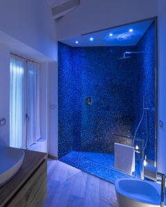 un bagno con ampia doccia e piastrelle blu di White Moon crema & Parking a Crema