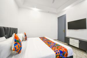 a bedroom with a bed and a flat screen tv at FabHotel The Premium Villa in Faridabad