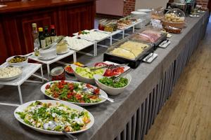a buffet with many plates of food on a table at Hotel Młyn Aqua Spa Biblioteka in Elblag