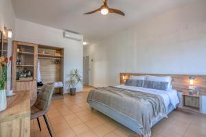 Kaliviani Traditional Hotel في كيساموس: غرفة نوم بسرير كبير ومروحة سقف