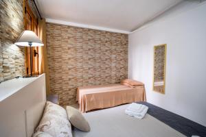 a room with two beds and a brick wall at Villa Gaudì - Batllò in Sant'Isidoro