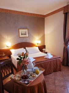 a hotel room with two beds and a tray of food at Hotel Squarciarelli in Grottaferrata