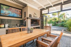 Un comedor con mesa y sillas de madera. en Caledon 23 Guest House, en George
