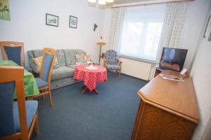 ein Wohnzimmer mit einem Sofa und einem Tisch in der Unterkunft Haus Ufen - In den Dünen 18c in Norderney