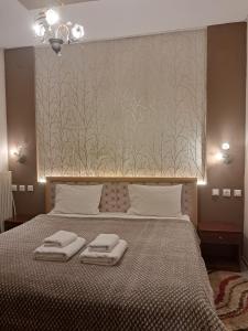 sypialnia z łóżkiem i dwoma ręcznikami na nim w obiekcie Erodios Guesthouse w mieście Kato Loutraki