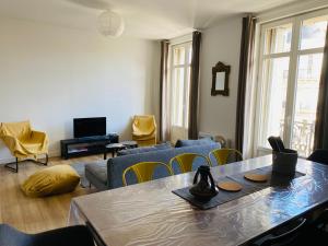un soggiorno con tavolo e sedie di Magnifique Appartement T4 90 M2 très bien situé 2 min Vieux port et Gare St Charles a Marsiglia