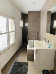 bagno con lavandino, vasca e finestra di Magnifique Appartement T4 90 M2 très bien situé 2 min Vieux port et Gare St Charles a Marsiglia
