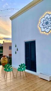 zwei Stühle vor einer weißen Wand in der Unterkunft Terrazza Levante in Otranto