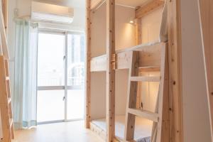 宫古岛ONE Miyakojima的客房设有带窗户的双层床。