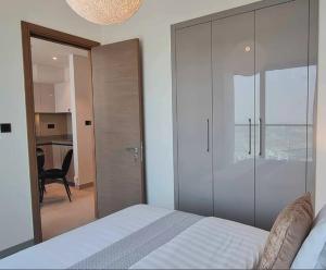 1 dormitorio con 1 cama y puerta corredera de cristal en Azizi Riviera Small Family Private Apartment Dubai, en Dubái