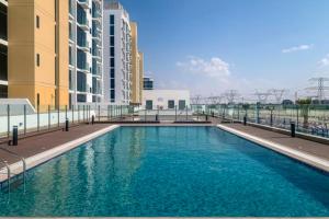 a large swimming pool in front of some buildings at Azizi Riviera Small Family Private Apartment Dubai in Dubai