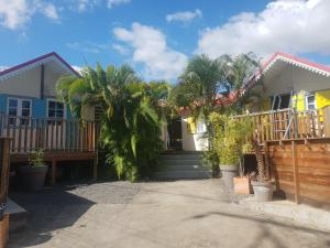 una casa con palmeras delante en Bungalow des papayes, en Saint-Louis