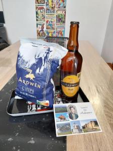 - une bouteille de bière et un sac d'alcool sur une table dans l'établissement Les 4 Fils Aymon, à Bogny Sur Meuse